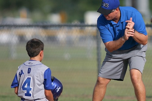 Afbeelding coach die kind aanmoedigd